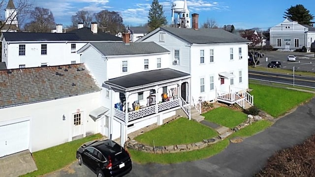 exterior space with a porch, a residential view, and a lawn