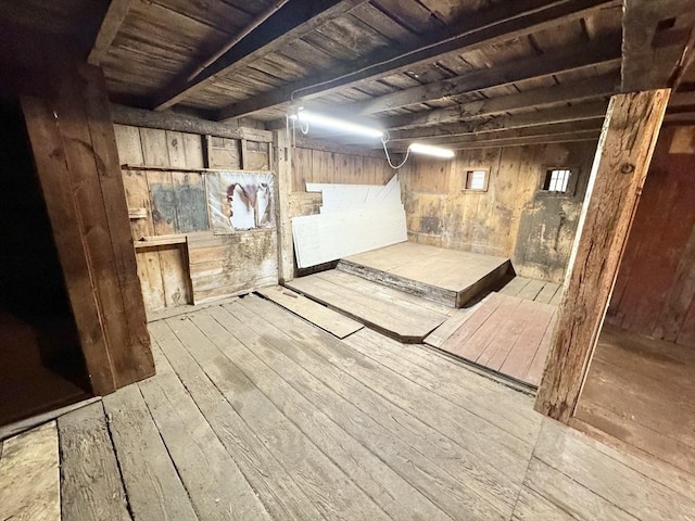 unfinished basement featuring wooden ceiling, wood walls, and hardwood / wood-style floors