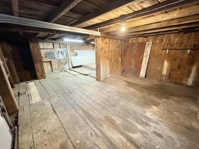 unfinished basement featuring wood ceiling, wooden walls, and hardwood / wood-style floors