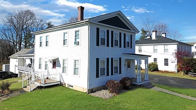 exterior space featuring a chimney and a front lawn