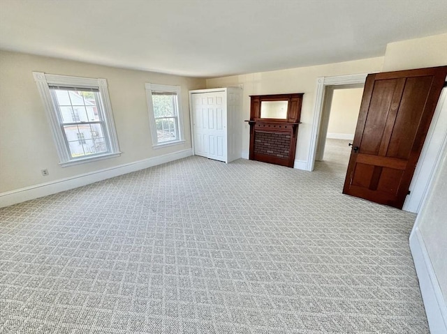 unfurnished bedroom with a closet, light colored carpet, and baseboards