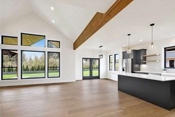 kitchen featuring pendant lighting, high vaulted ceiling, dark hardwood / wood-style floors, beam ceiling, and stainless steel fridge with ice dispenser