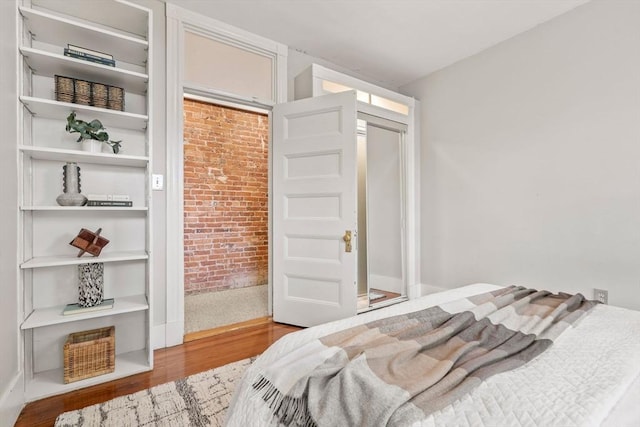 48 Kent St Unit 1, Brookline, MA 02445 - bedroom featuring wood finished floors and brick wall