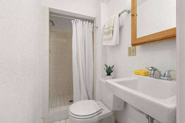 48 Kent St Unit 1, Brookline, MA 02445 - bathroom featuring toilet, a sink, a shower stall, and a textured wall