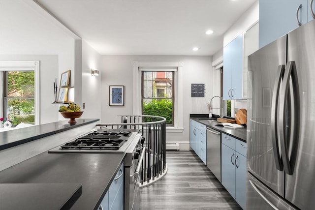 48 Kent St Unit 1, Brookline, MA 02445 - kitchen featuring stainless steel appliances, dark countertops, a sink, dark wood finished floors, and recessed lighting