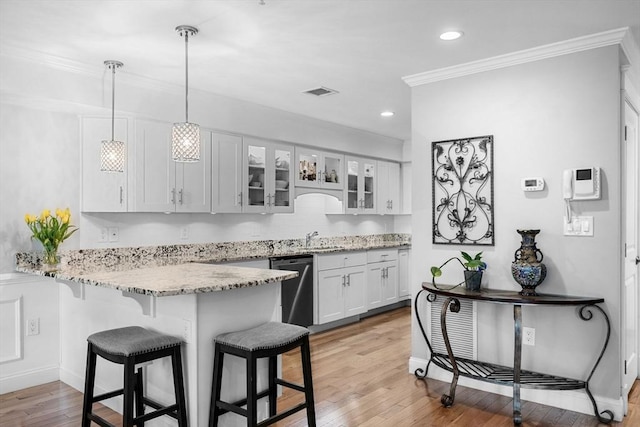 100 Burrill St Unit 3, Swampscott, MA 01907 - kitchen with a breakfast bar area, a peninsula, dishwasher, white cabinets, and glass insert cabinets