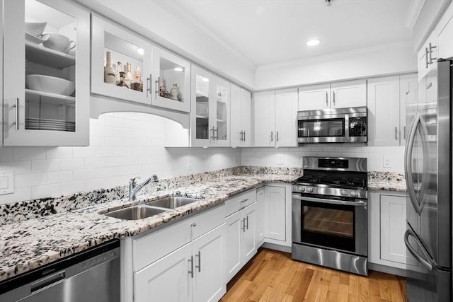 100 Burrill St Unit 3, Swampscott, MA 01907 - kitchen featuring stainless steel appliances, a sink, crown molding, white cabinetry, and light stone countertops