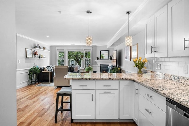 100 Burrill St Unit 3, Swampscott, MA 01907 - kitchen featuring stainless steel dishwasher, open floor plan, a peninsula, ornamental molding, and white cabinetry