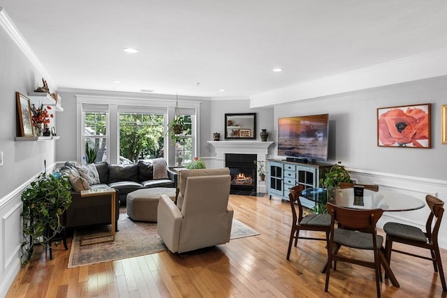100 Burrill St Unit 3, Swampscott, MA 01907 - living room with ornamental molding, a fireplace with flush hearth, light wood-type flooring, wainscoting, and a decorative wall