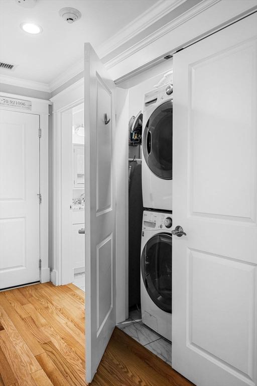 100 Burrill St Unit 3, Swampscott, MA 01907 - laundry room featuring stacked washer / drying machine, crown molding, wood finished floors, and recessed lighting