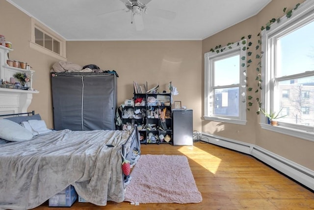 201 High St, Brookline, MA 02445 - bedroom featuring a baseboard radiator, wood finished floors, crown molding, and ceiling fan
