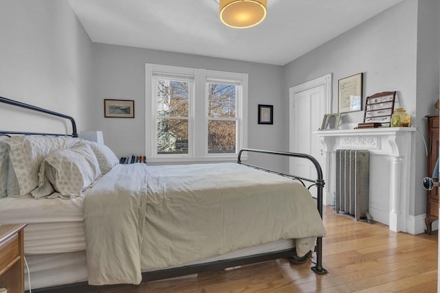 201 High St, Brookline, MA 02445 - bedroom featuring radiator heating unit and wood finished floors