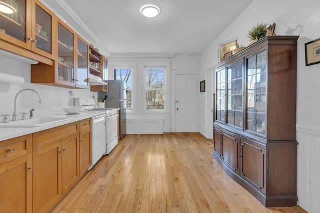 201 High St, Brookline, MA 02445 - kitchen with a sink, white appliances, light wood-type flooring, light countertops, and glass insert cabinets