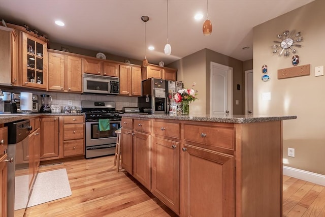 578-580 Detroit St, Fall River, MA 02721 - kitchen featuring stainless steel appliances, light wood finished floors, backsplash, a center island, and decorative light fixtures