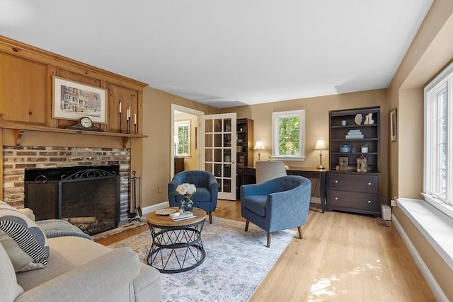 62 Waite Rd, Boxborough, MA 01719 - living room featuring light wood-style flooring, a brick fireplace, and baseboards