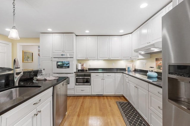 62 Waite Rd, Boxborough, MA 01719 - kitchen featuring appliances with stainless steel finishes, under cabinet range hood, a sink, light wood finished floors, and white cabinetry