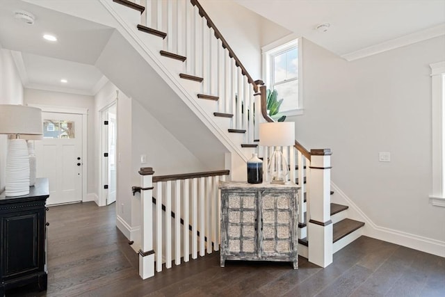 stairway featuring baseboards, a healthy amount of sunlight, and wood finished floors