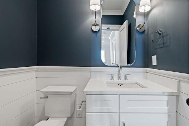 bathroom featuring vanity, crown molding, and toilet