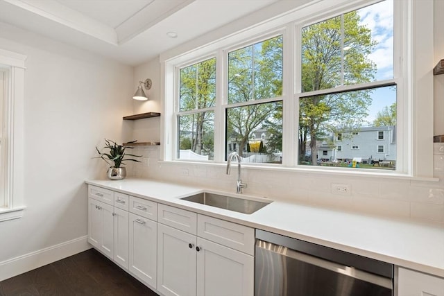 kitchen featuring a sink, light countertops, backsplash, and dishwasher
