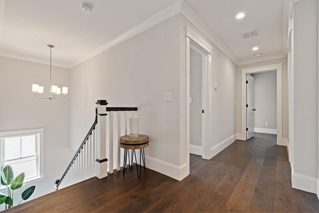 hallway featuring an inviting chandelier, baseboards, dark wood-style floors, and an upstairs landing
