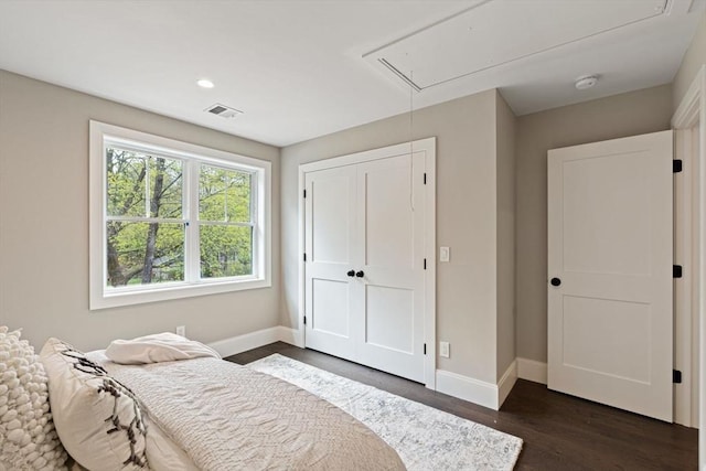 bedroom featuring baseboards, attic access, dark wood-style floors, and visible vents