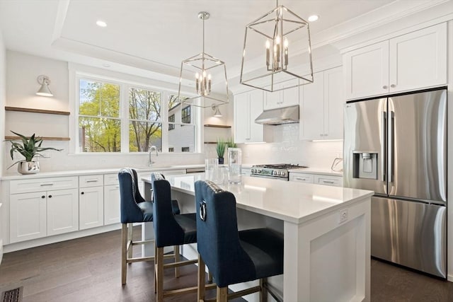 kitchen featuring under cabinet range hood, open shelves, appliances with stainless steel finishes, and an inviting chandelier