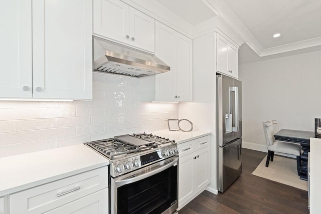 kitchen with dark wood-style flooring, light countertops, stainless steel appliances, decorative backsplash, and under cabinet range hood