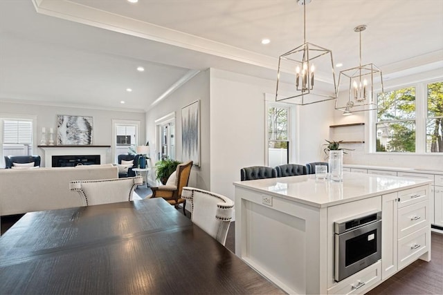 kitchen featuring crown molding, a center island, white cabinets, and recessed lighting