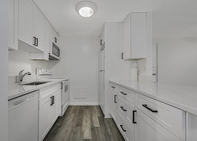 64 Main St Unit 25B, Stoneham, MA 02180 - kitchen featuring white appliances, a textured ceiling, white cabinetry, backsplash, and light stone counters