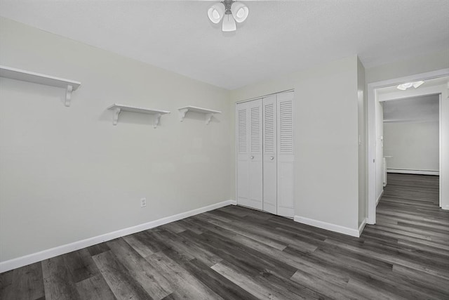 64 Main St Unit 25B, Stoneham, MA 02180 - unfurnished bedroom with dark wood-type flooring, a closet, and a baseboard heating unit