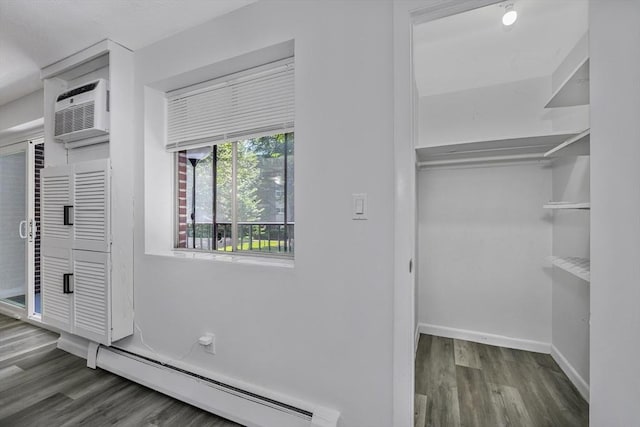 64 Main St Unit 25B, Stoneham, MA 02180 - walk in closet featuring a baseboard radiator, wood finished floors, and a wall mounted air conditioner