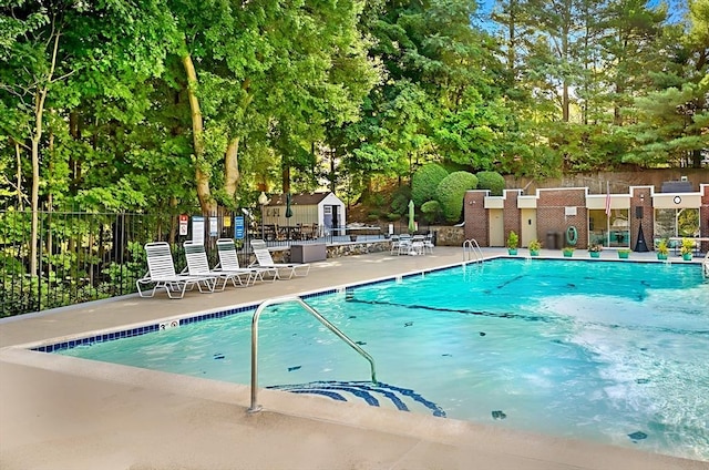 64 Main St Unit 25B, Stoneham, MA 02180 - community pool featuring view of wooded area, a patio, and a shed