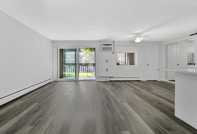 64 Main St Unit 25B, Stoneham, MA 02180 - unfurnished living room with baseboard heating, an AC wall unit, a ceiling fan, and wood finished floors
