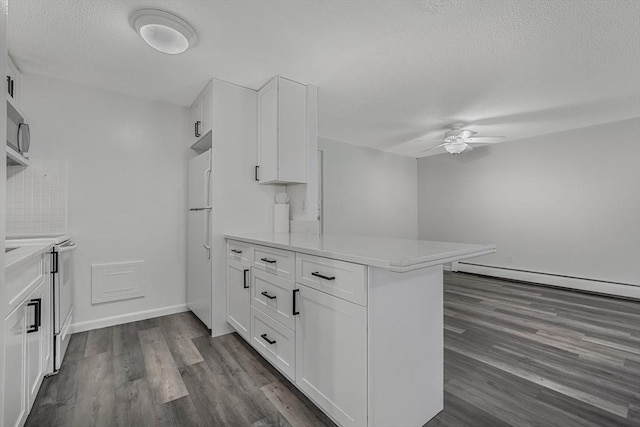 64 Main St Unit 25B, Stoneham, MA 02180 - kitchen featuring white appliances, a peninsula, ceiling fan, white cabinetry, and a textured ceiling