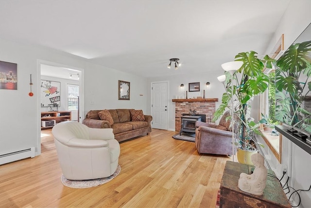 17 Lantern Ln, Leominster, MA 01453 - living area with light wood-type flooring, a wood stove, and a baseboard radiator