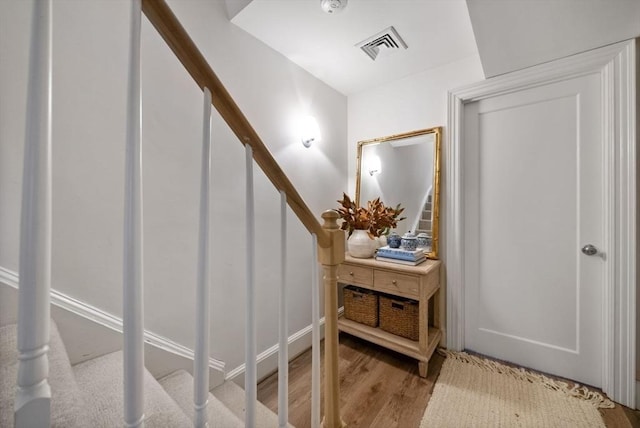 interior space with stairway, wood finished floors, and visible vents