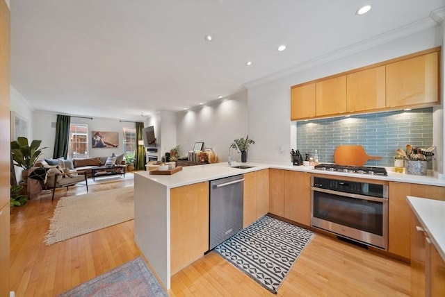 kitchen with stainless steel appliances, a peninsula, and light wood finished floors