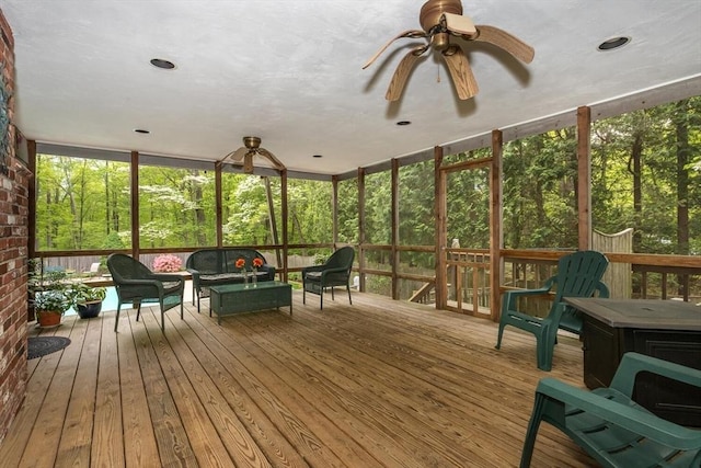 sunroom featuring a ceiling fan, an outdoor living space, and french doors