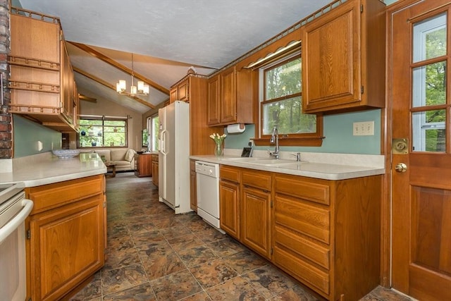kitchen with a sink, white appliances, a chandelier, vaulted ceiling, and brown cabinets