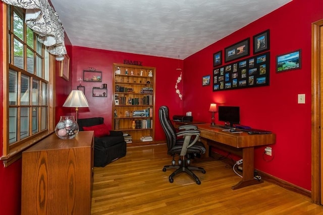 office space with wood finished floors, a textured ceiling, and baseboards