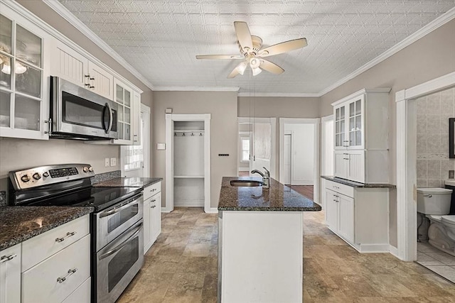 30 Whipple St, Worcester, MA 01607 - kitchen featuring stainless steel appliances, a center island with sink, a ceiling fan, white cabinetry, and dark stone countertops