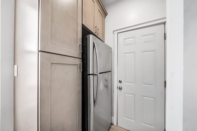 kitchen with stainless steel fridge and light brown cabinetry