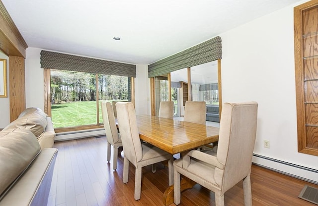 dining space featuring baseboard heating, wood finished floors, and recessed lighting