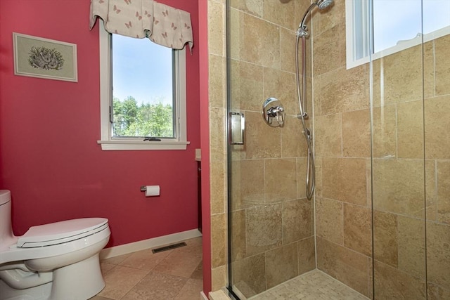 full bath featuring a stall shower, toilet, baseboards, and tile patterned flooring
