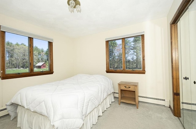 bedroom featuring a baseboard heating unit and light carpet