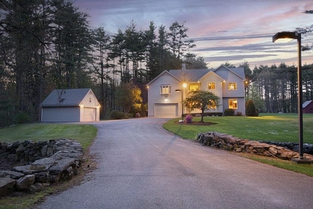 view of front facade featuring an outbuilding, a front yard, driveway, and a chimney