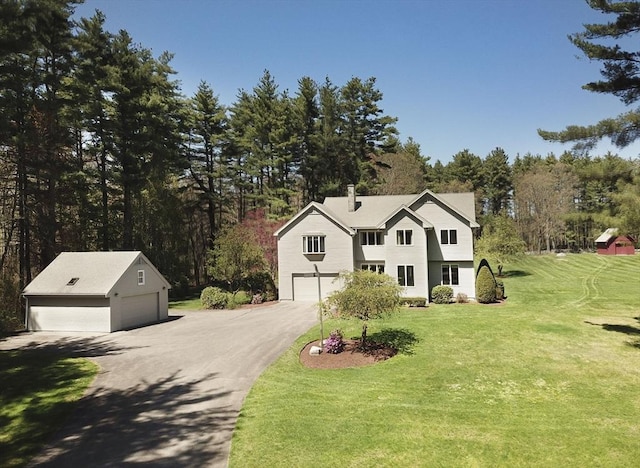 traditional-style home featuring a front yard, view of scattered trees, and an outdoor structure
