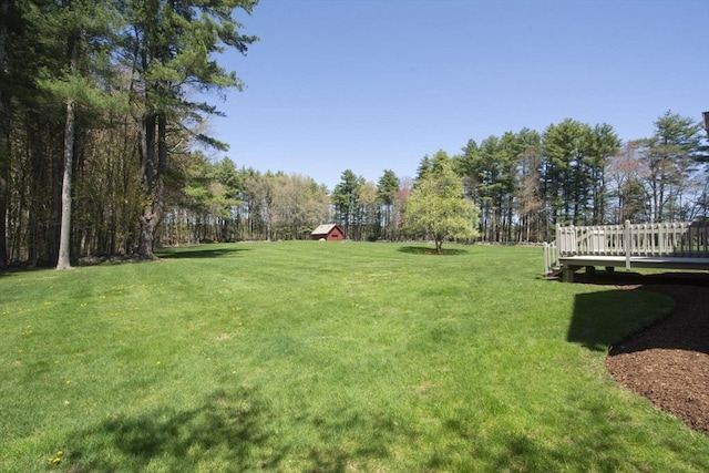 view of grassy yard with a deck