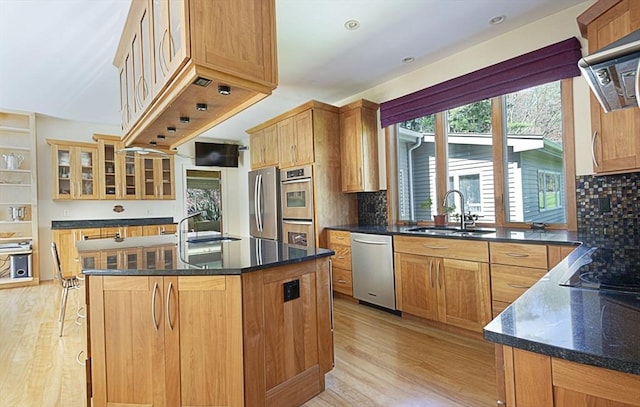 kitchen featuring stainless steel appliances, a sink, light wood-style flooring, and recessed lighting
