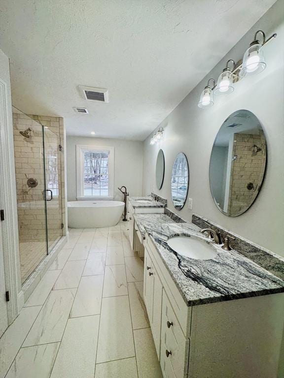 200A Randall Rd, Berlin, MA 01503 - full bath featuring double vanity, a stall shower, a freestanding tub, a textured ceiling, and marble look tiles